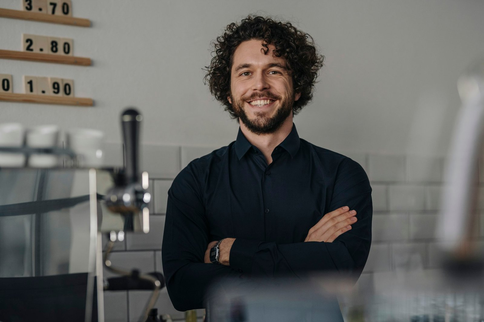 Proud coffee shop owner standing behind counter