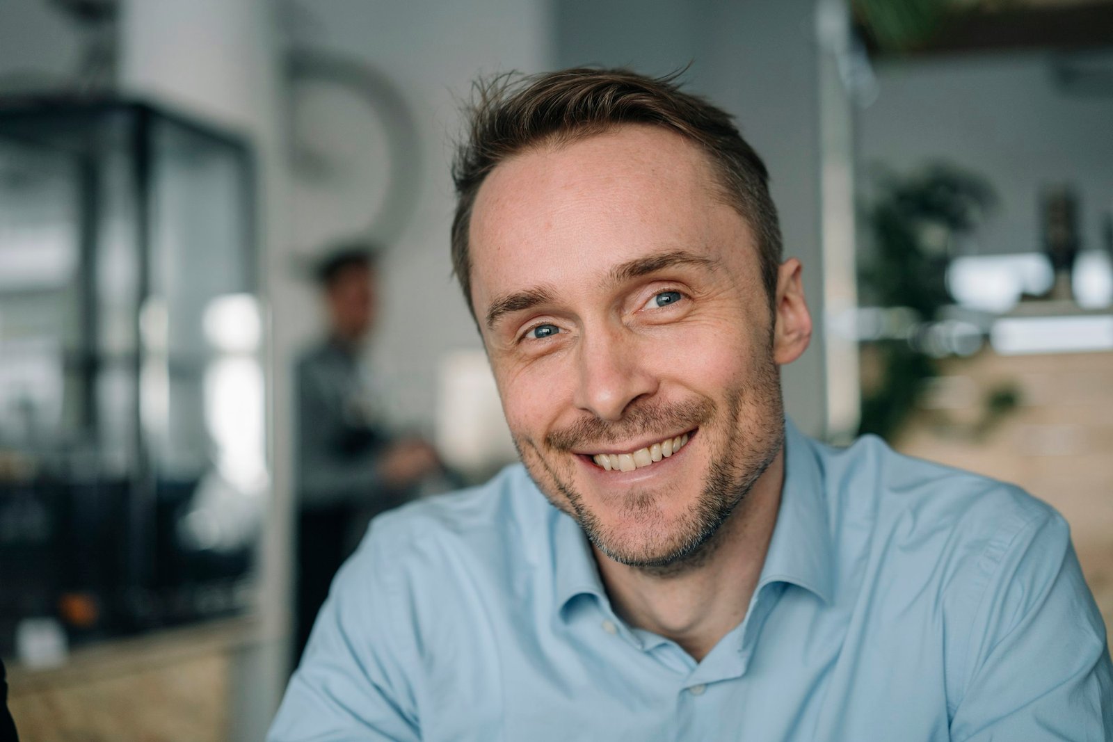 Successful businessman sitting in coffee shop, smiling